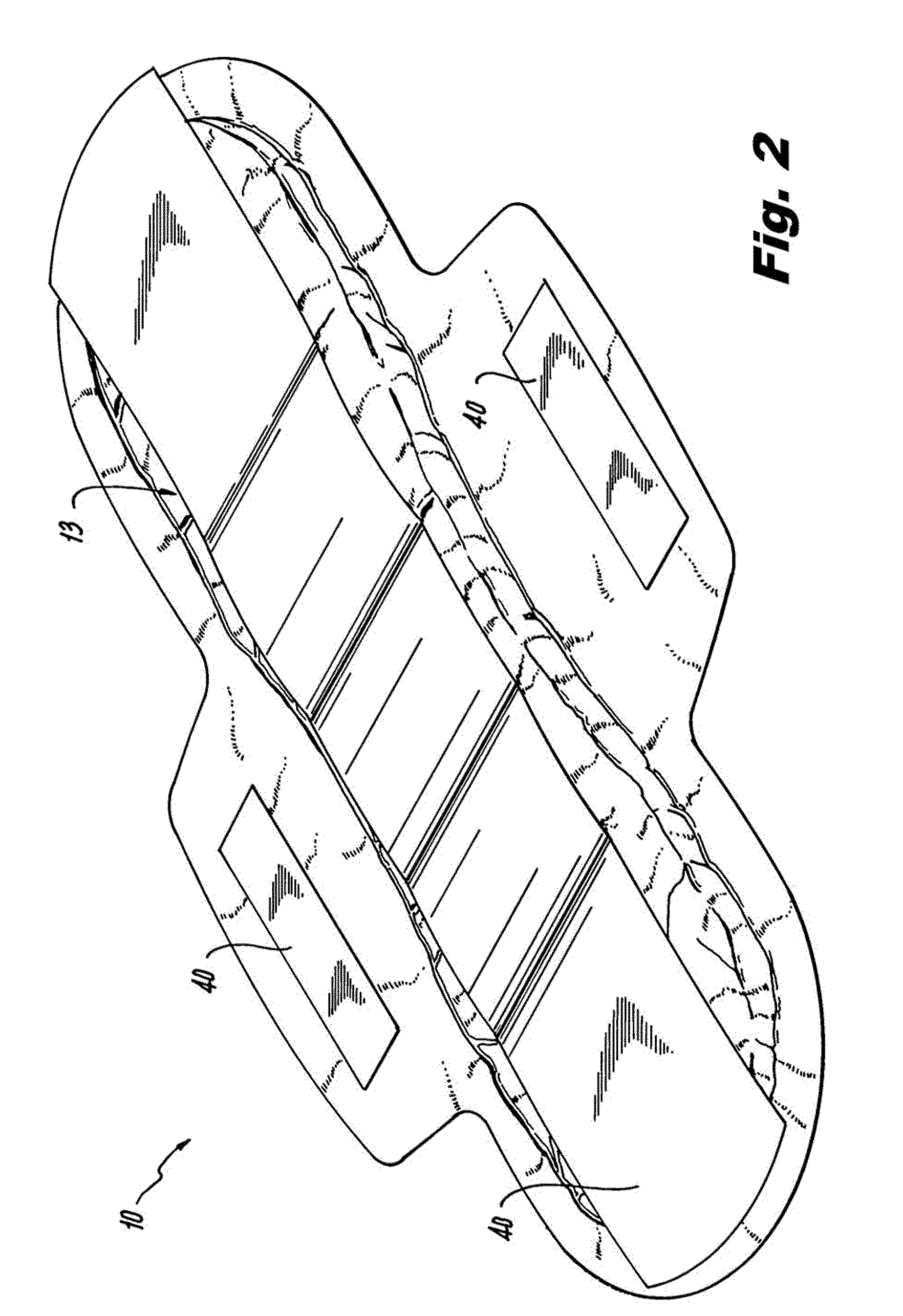 Absorbent article including an absorbent core layer having a material free zone and a transfer layer arranged below the absorbent core layer
