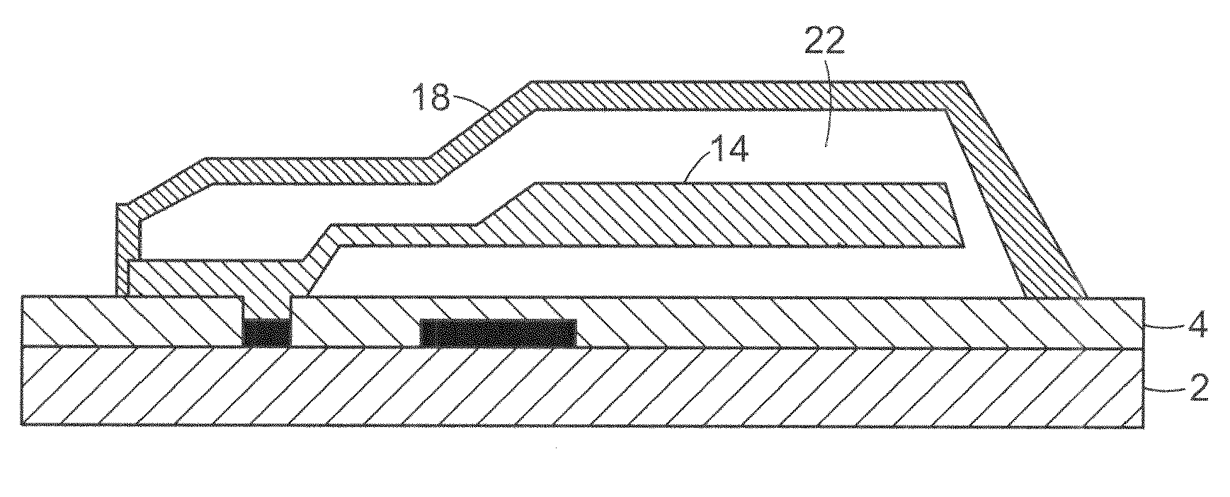 Micromachined assembly with a multi-layer cap defining a cavity