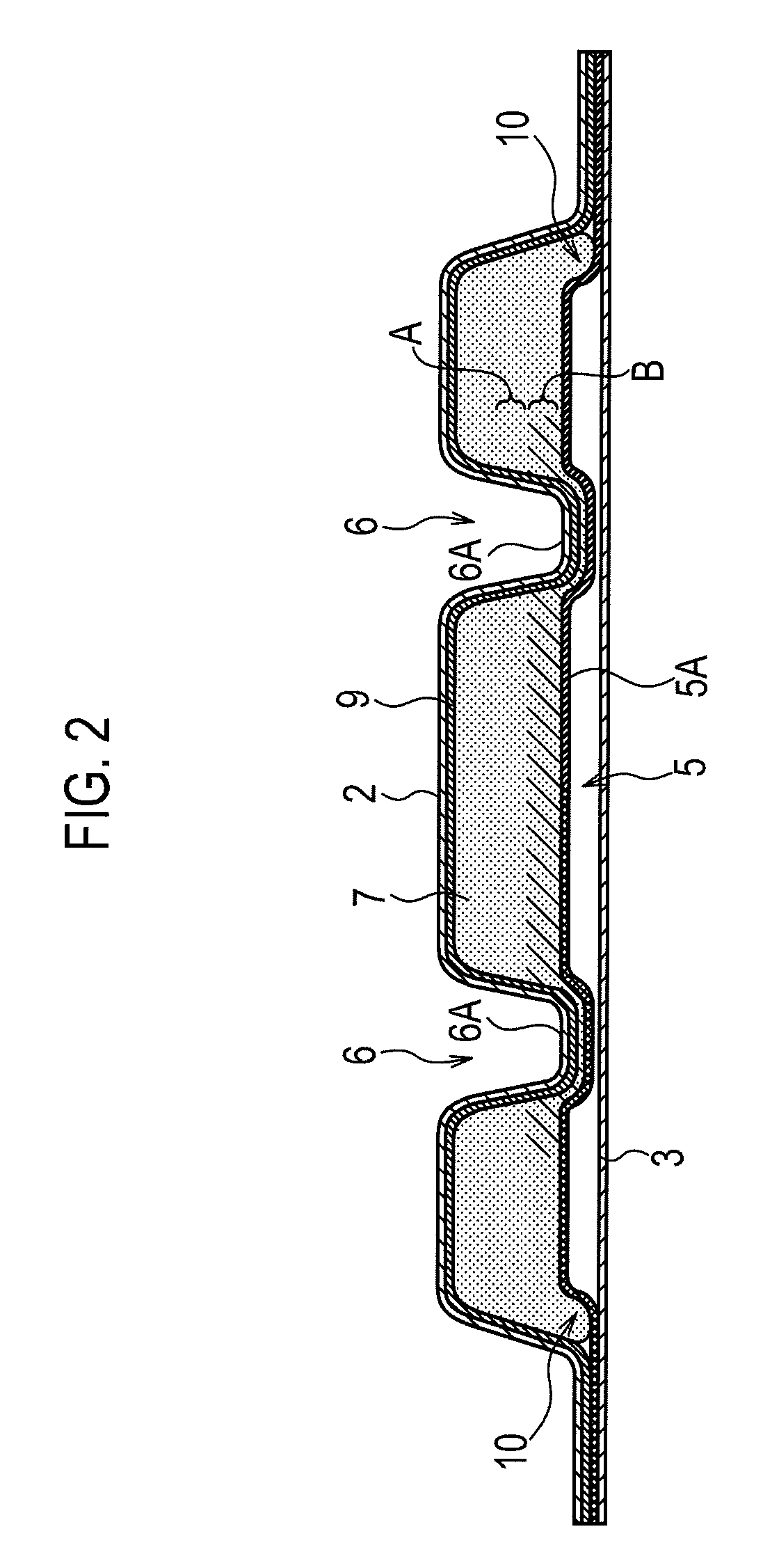 Absorbent article with pressed grooves overlying a compressed region and method of manufacturing the same